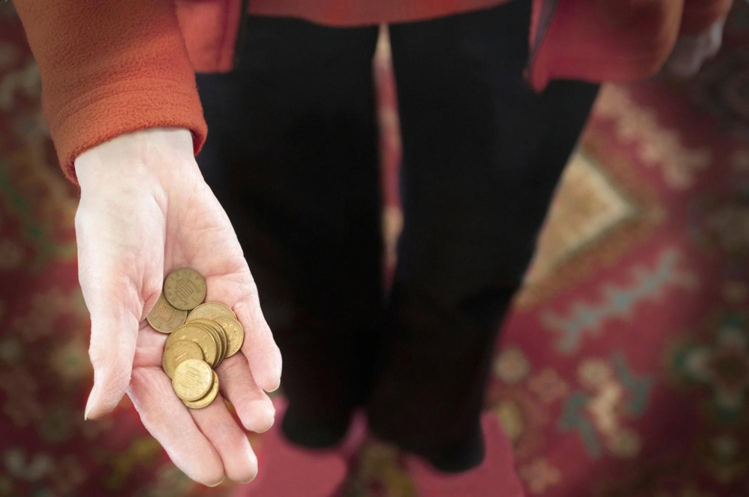 A hand holding a few small coins, symbolising how lifestyle inflation drains UAE salaries