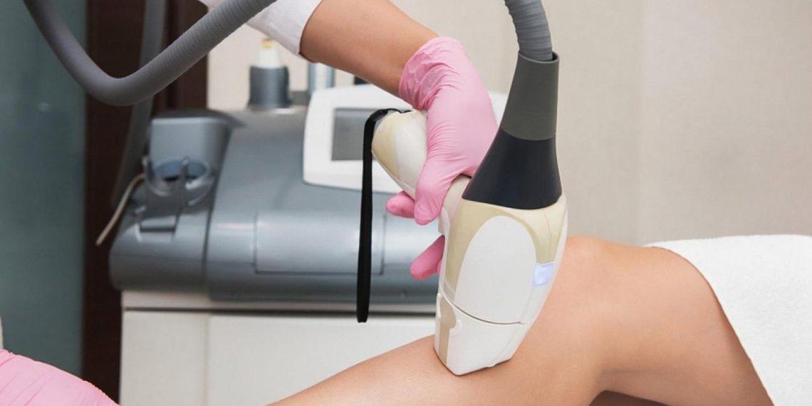 Aesthetician performing a laser resurfacing treatment on a patient's leg in a UAE clinic